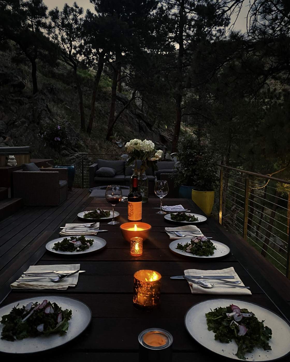 Dinner set on the deck at dusk with candles